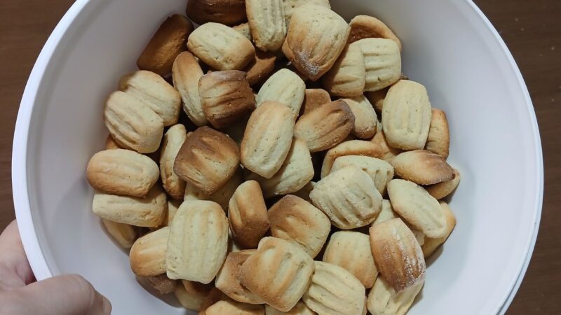Biscoitos caseiros amanteigados estilo 'nhoque' com marcas de garfo, dourados e crocantes, apresentados de forma artesanal para o café da tarde.